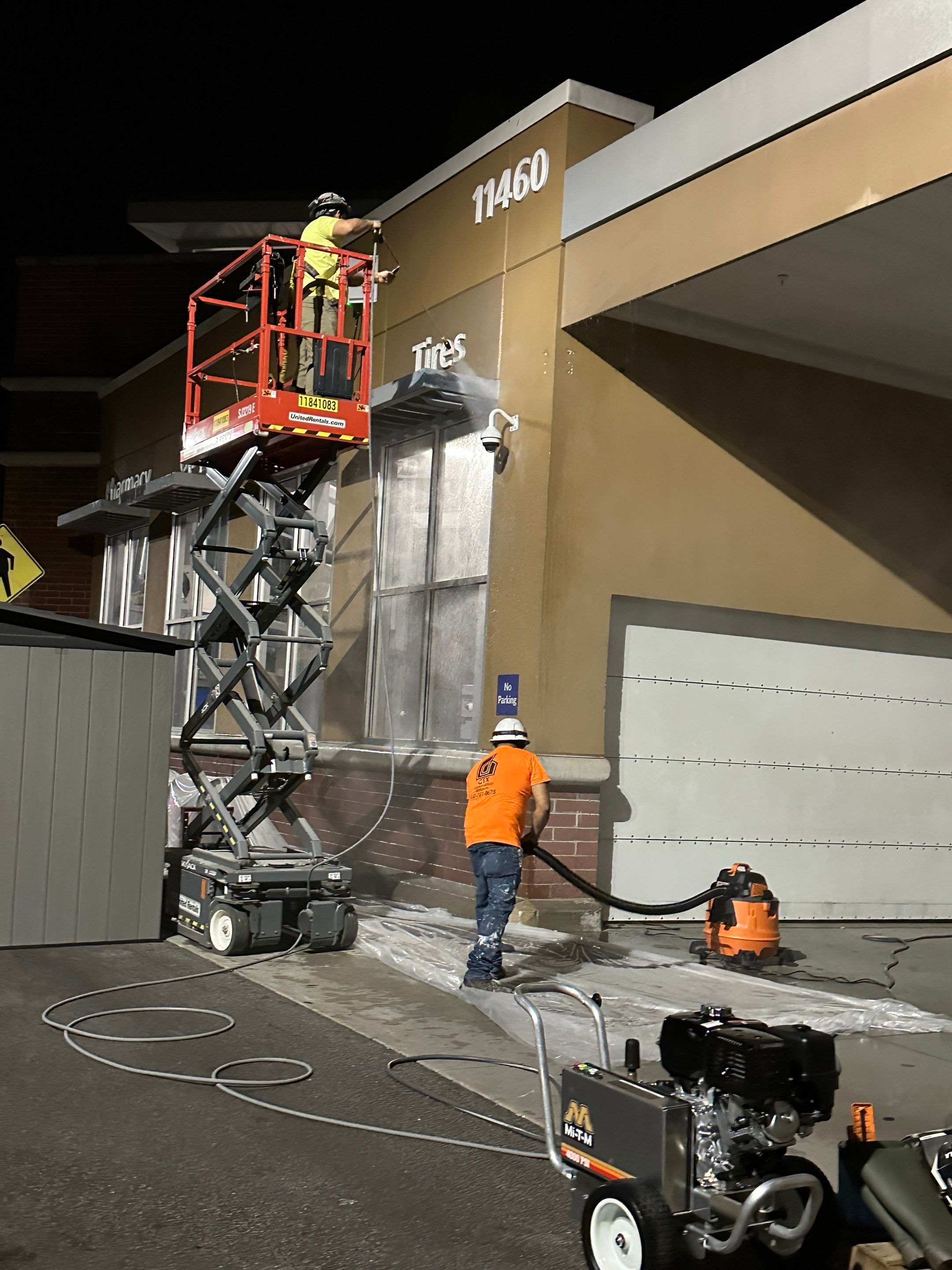 Coatings crew working from a lift during an overnight exterior paint operation
