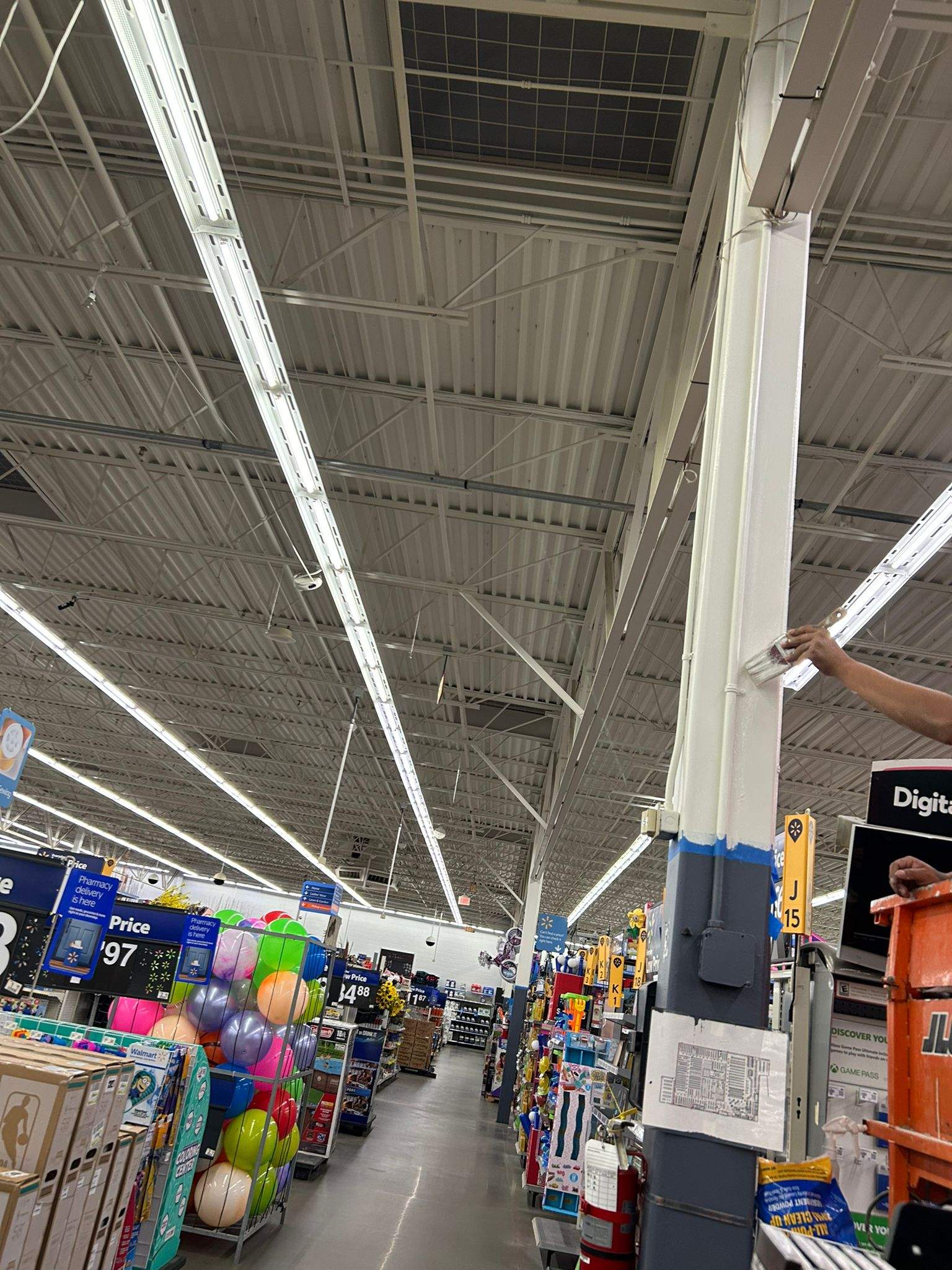 Painter brush-applying a precise finish coat to a retail column
